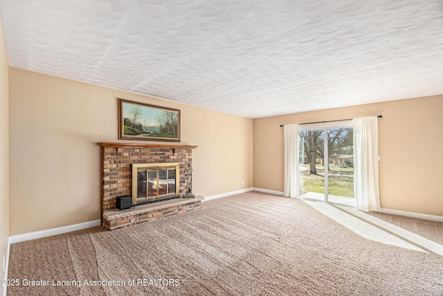 unfurnished living room featuring carpet flooring, a fireplace, baseboards, and a textured ceiling