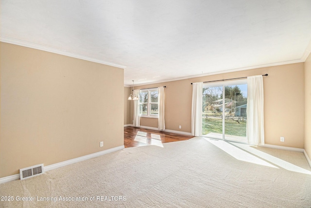 unfurnished room featuring crown molding, baseboards, visible vents, and a chandelier