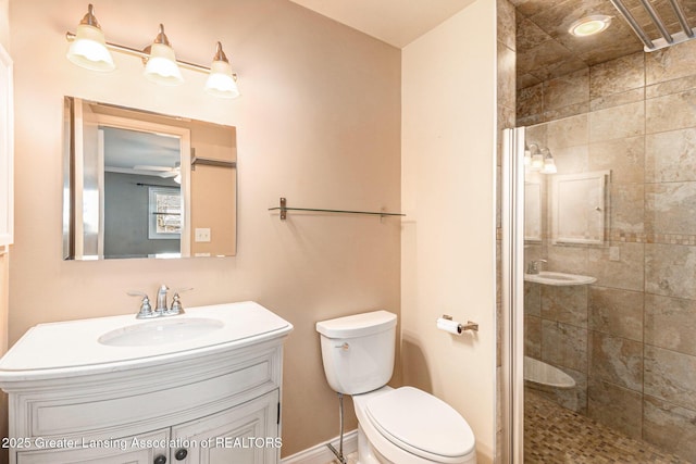 full bath featuring vanity, a ceiling fan, baseboards, a shower stall, and toilet