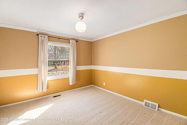 carpeted empty room featuring visible vents, baseboards, and ornamental molding