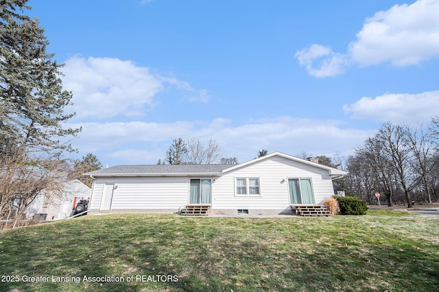 rear view of property with entry steps and a yard