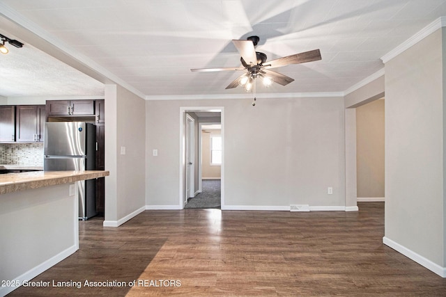 unfurnished living room featuring dark wood finished floors, baseboards, ceiling fan, and ornamental molding