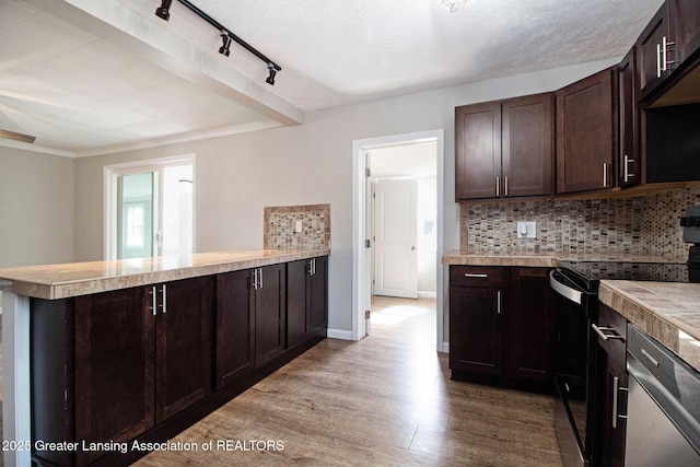 kitchen with electric range, dark brown cabinetry, a peninsula, light countertops, and decorative backsplash