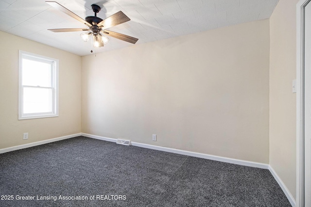 spare room with visible vents, baseboards, ceiling fan, and dark carpet