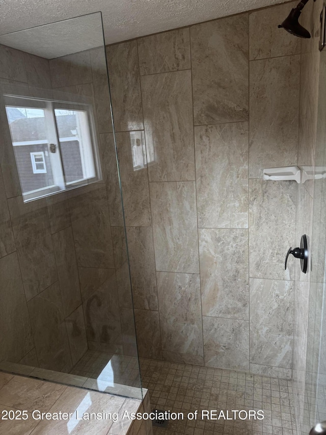 bathroom featuring a textured ceiling and walk in shower