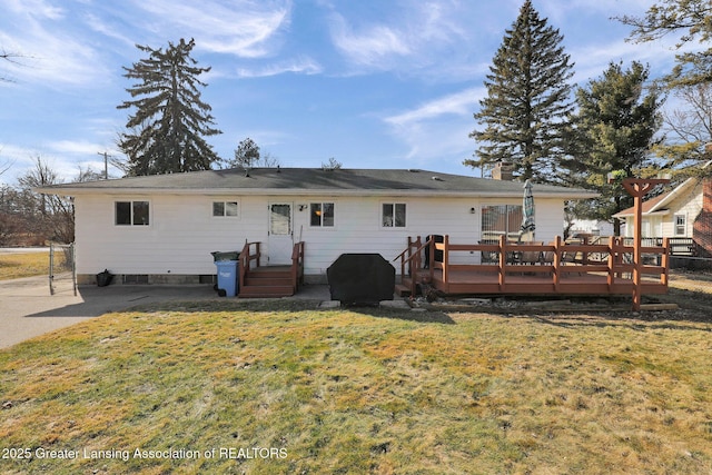 back of house featuring a wooden deck, a lawn, fence, and a chimney