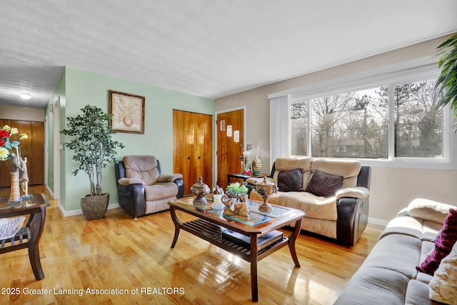 living area featuring light wood-style flooring and baseboards