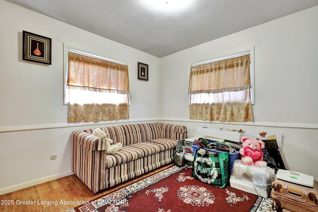 living area with baseboards and wood finished floors