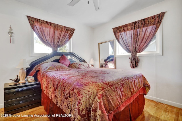 bedroom featuring baseboards, light wood-style flooring, and a ceiling fan