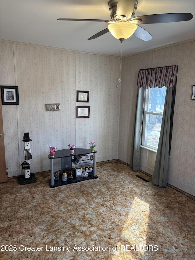 interior space with baseboards, a ceiling fan, and wallpapered walls