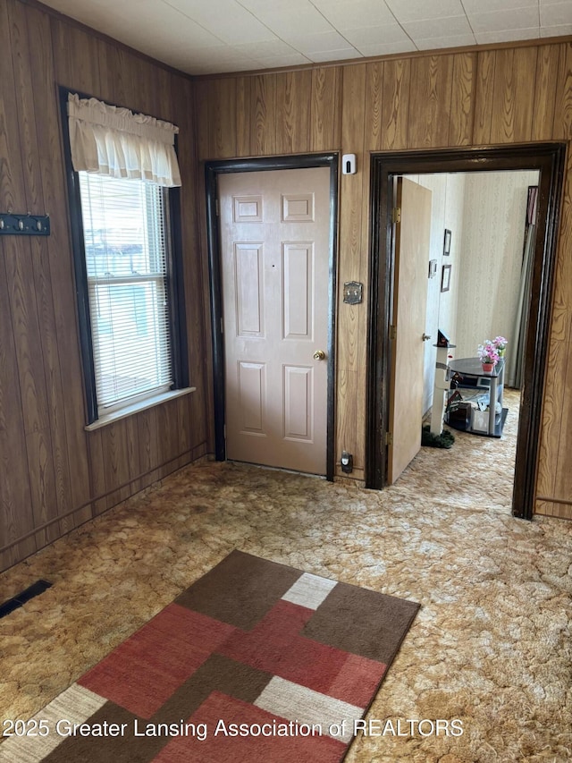 foyer featuring wooden walls