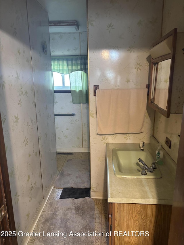 bathroom featuring wallpapered walls and vanity