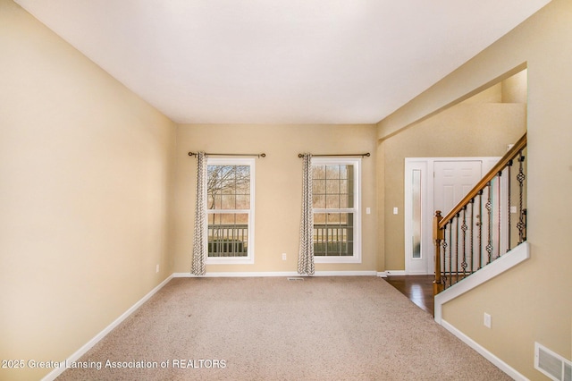 empty room with stairs, carpet, baseboards, and visible vents