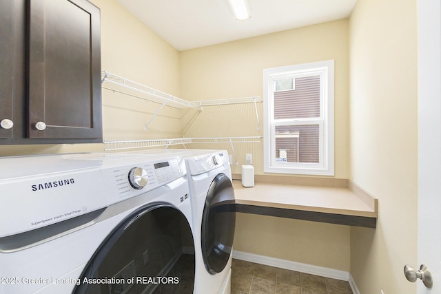 laundry area with washing machine and clothes dryer, cabinet space, and baseboards