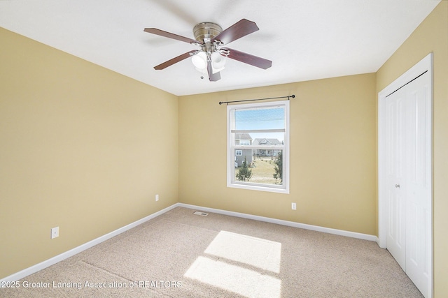 unfurnished bedroom with visible vents, baseboards, carpet flooring, a closet, and a ceiling fan