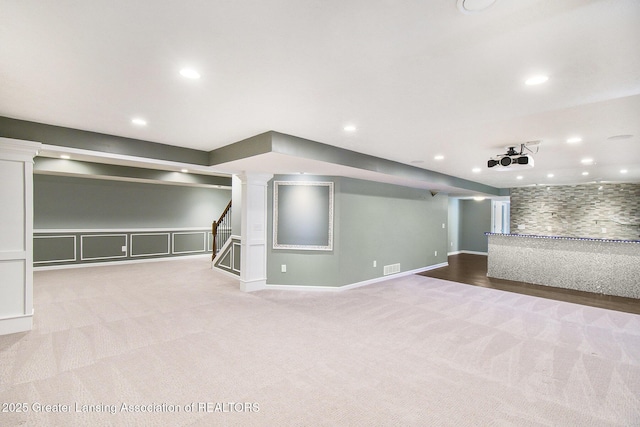 finished below grade area with visible vents, recessed lighting, carpet floors, baseboards, and stairs