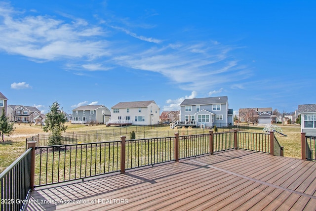 deck with a residential view, a lawn, and fence