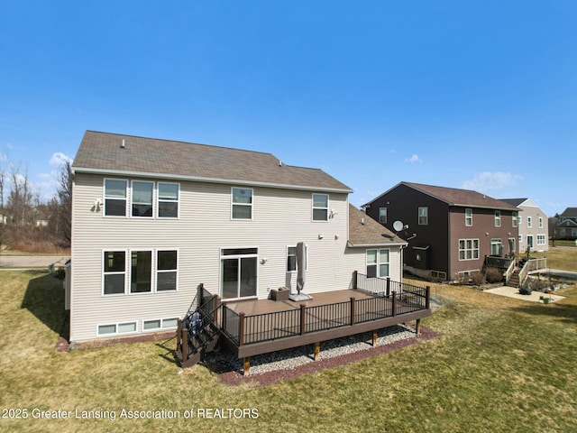 rear view of property with a yard and a wooden deck