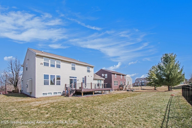 back of property featuring a yard, a residential view, and a deck