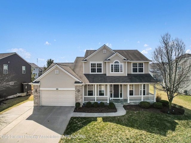 traditional home with a porch, concrete driveway, a front yard, and an attached garage