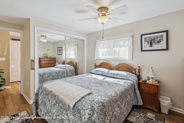 bedroom featuring a closet, a ceiling fan, baseboards, and wood finished floors