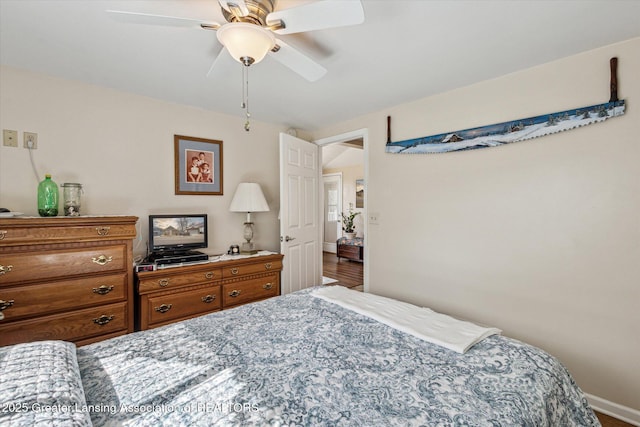 bedroom featuring wood finished floors, baseboards, and ceiling fan