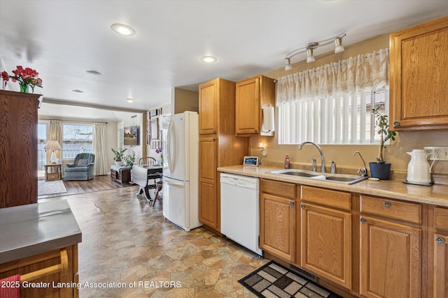 kitchen with white appliances, recessed lighting, light countertops, and a sink