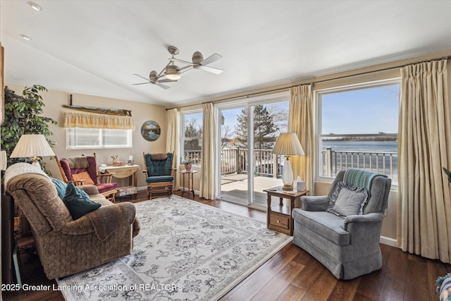 living area featuring vaulted ceiling, wood finished floors, baseboards, and ceiling fan