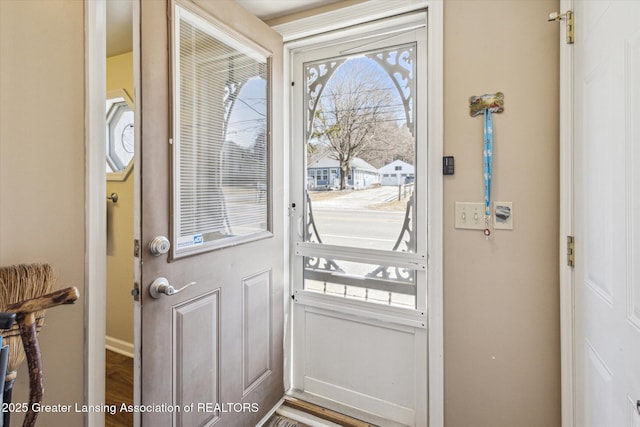 doorway to outside featuring baseboards