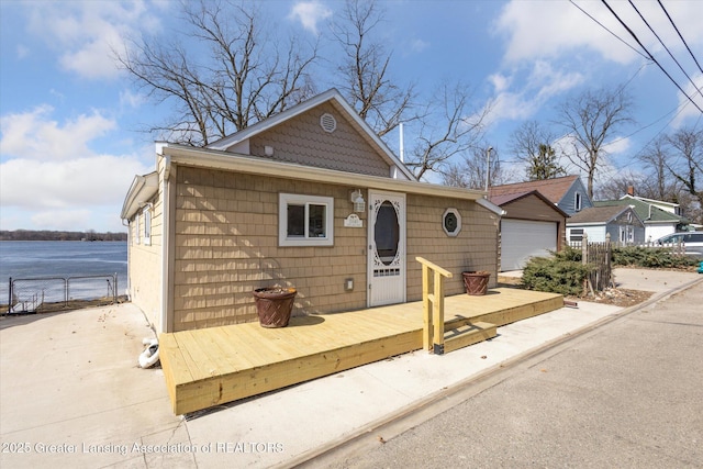 view of front facade featuring a deck, fence, and a garage