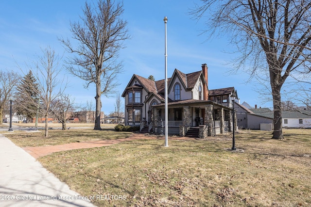 view of front facade featuring a front yard, a porch, and stone siding