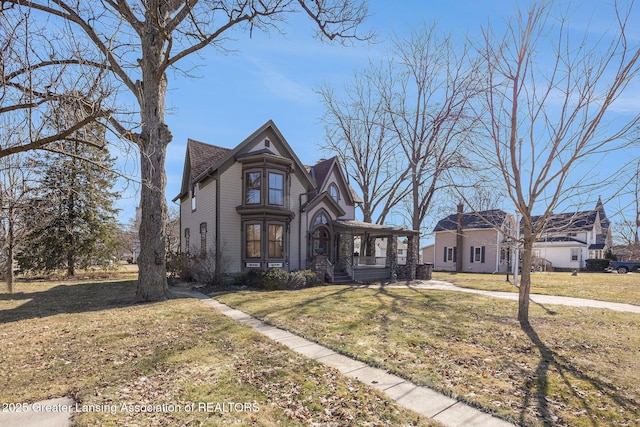 victorian home featuring a front lawn