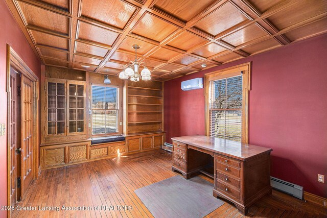 unfurnished office featuring hardwood / wood-style floors, a wall unit AC, coffered ceiling, a baseboard heating unit, and a chandelier