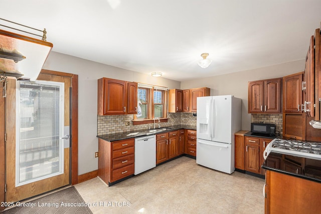 kitchen featuring white appliances, brown cabinets, backsplash, and a sink