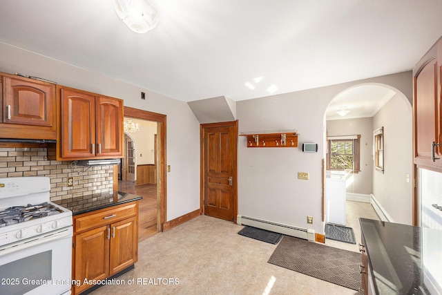 kitchen featuring dark countertops, white gas stove, decorative backsplash, arched walkways, and a baseboard radiator
