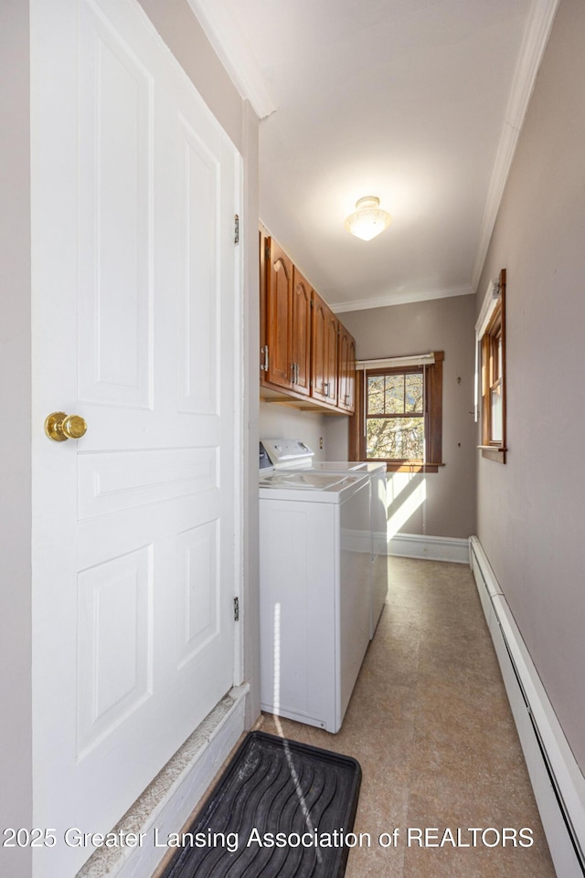 clothes washing area with crown molding, baseboards, washer and dryer, cabinet space, and a baseboard radiator