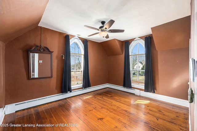 empty room featuring a baseboard radiator, lofted ceiling, a ceiling fan, and wood-type flooring