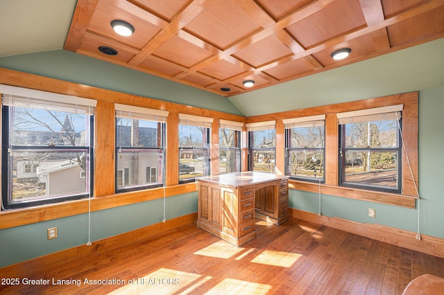 unfurnished office featuring a healthy amount of sunlight, light wood-type flooring, and lofted ceiling with beams