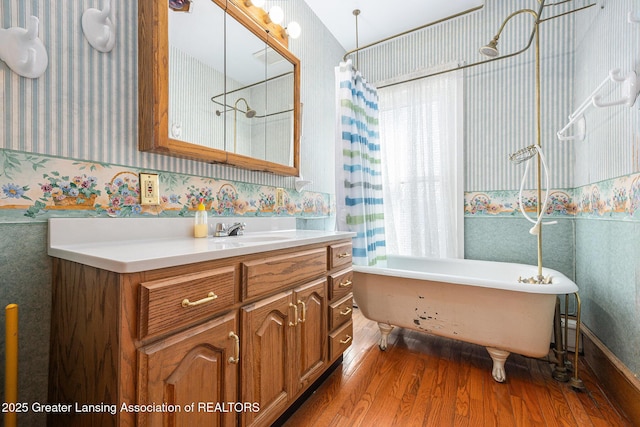 bathroom featuring a wealth of natural light, wood finished floors, and wallpapered walls
