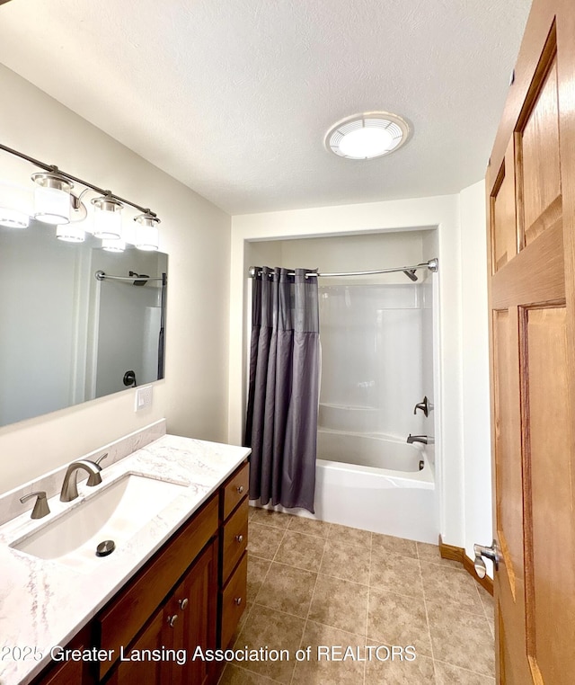 full bath with tile patterned floors, shower / bathtub combination with curtain, a textured ceiling, and vanity