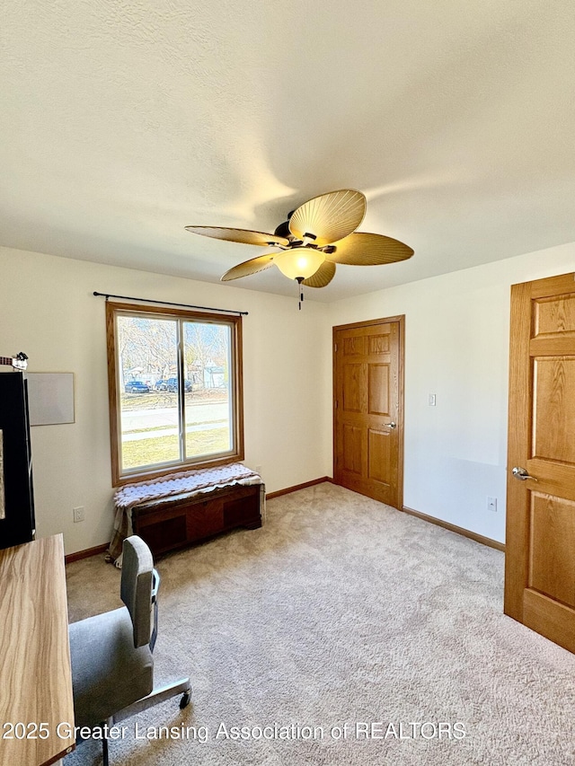 interior space featuring carpet flooring, baseboards, and ceiling fan