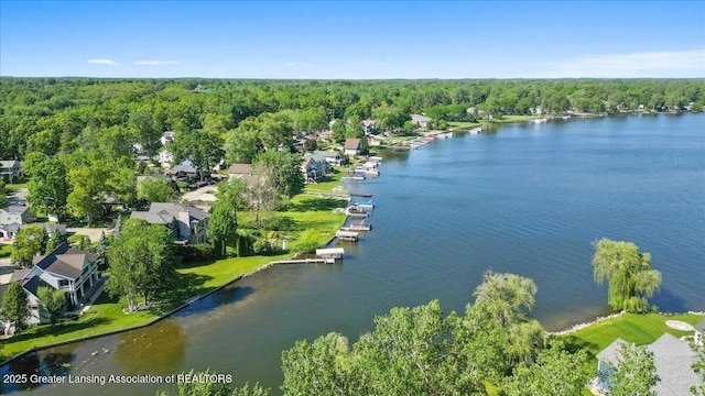 birds eye view of property with a wooded view and a water view