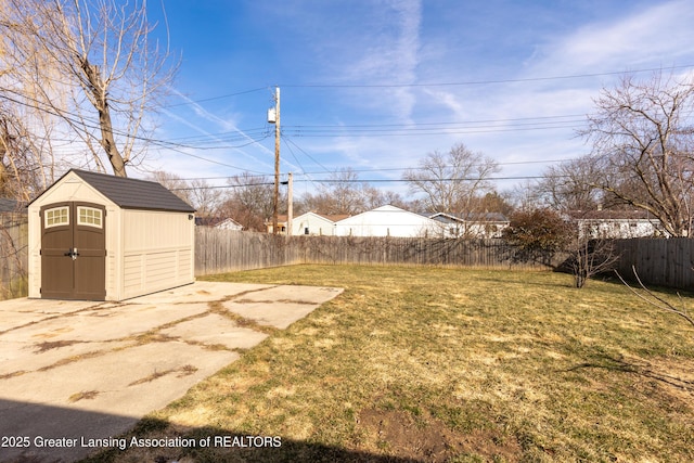 view of yard featuring a patio area, a storage unit, a fenced backyard, and an outdoor structure