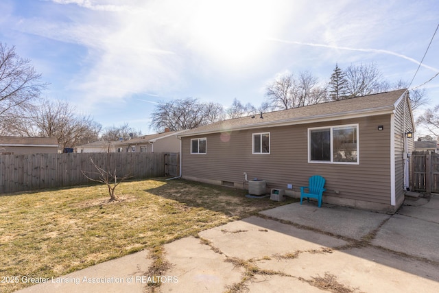 rear view of property with a lawn, a patio, central AC, and a fenced backyard