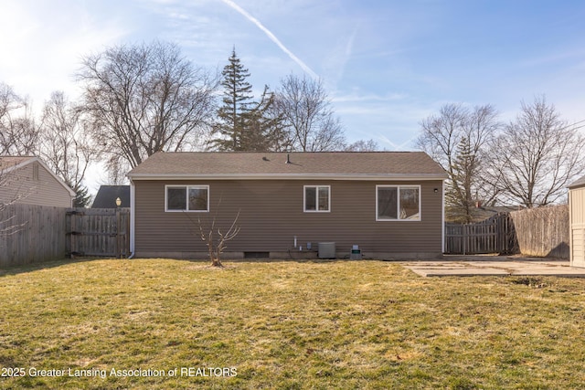 rear view of property featuring central AC unit, a yard, and a fenced backyard