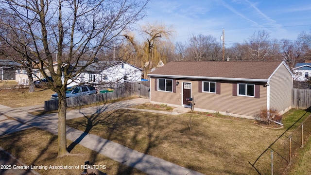 ranch-style house with a front lawn, fence, and a shingled roof