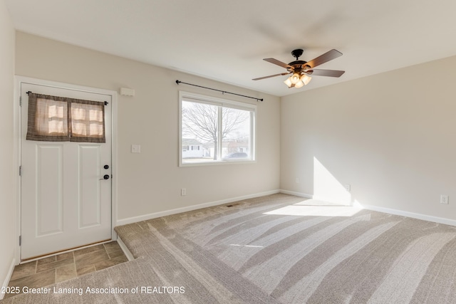 entrance foyer featuring light carpet, a ceiling fan, and baseboards