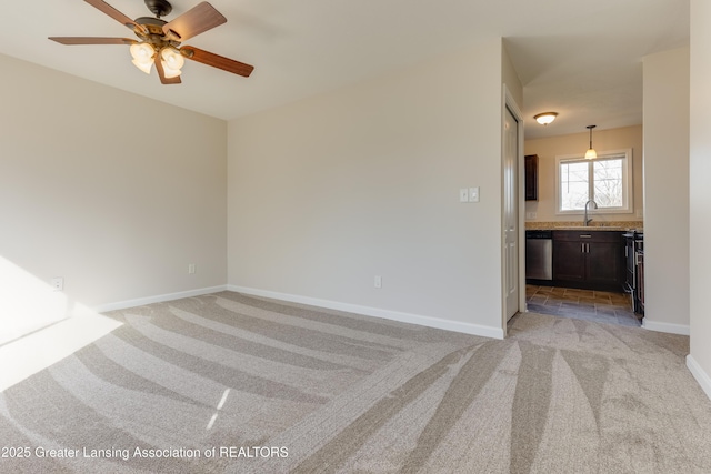 unfurnished living room featuring a sink, baseboards, light colored carpet, and ceiling fan