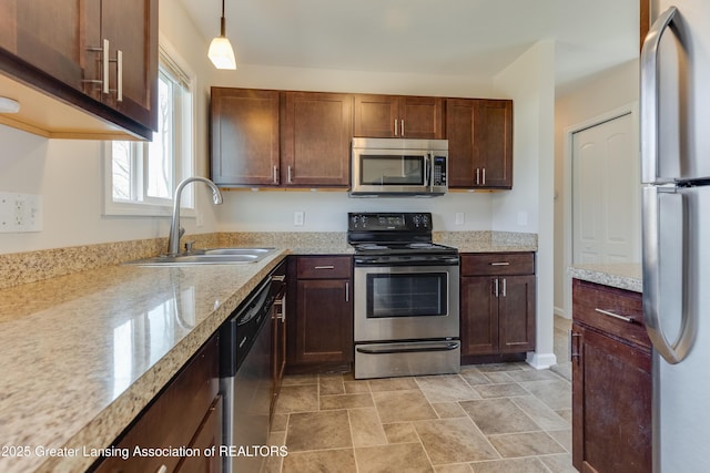 kitchen featuring hanging light fixtures, stainless steel appliances, and a sink