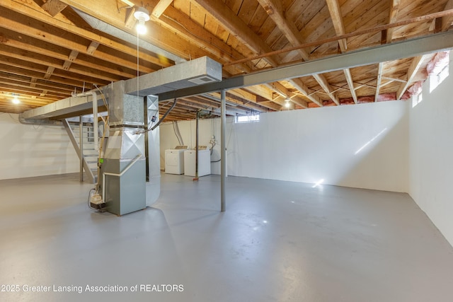 basement with heating unit, stairs, and washer and clothes dryer